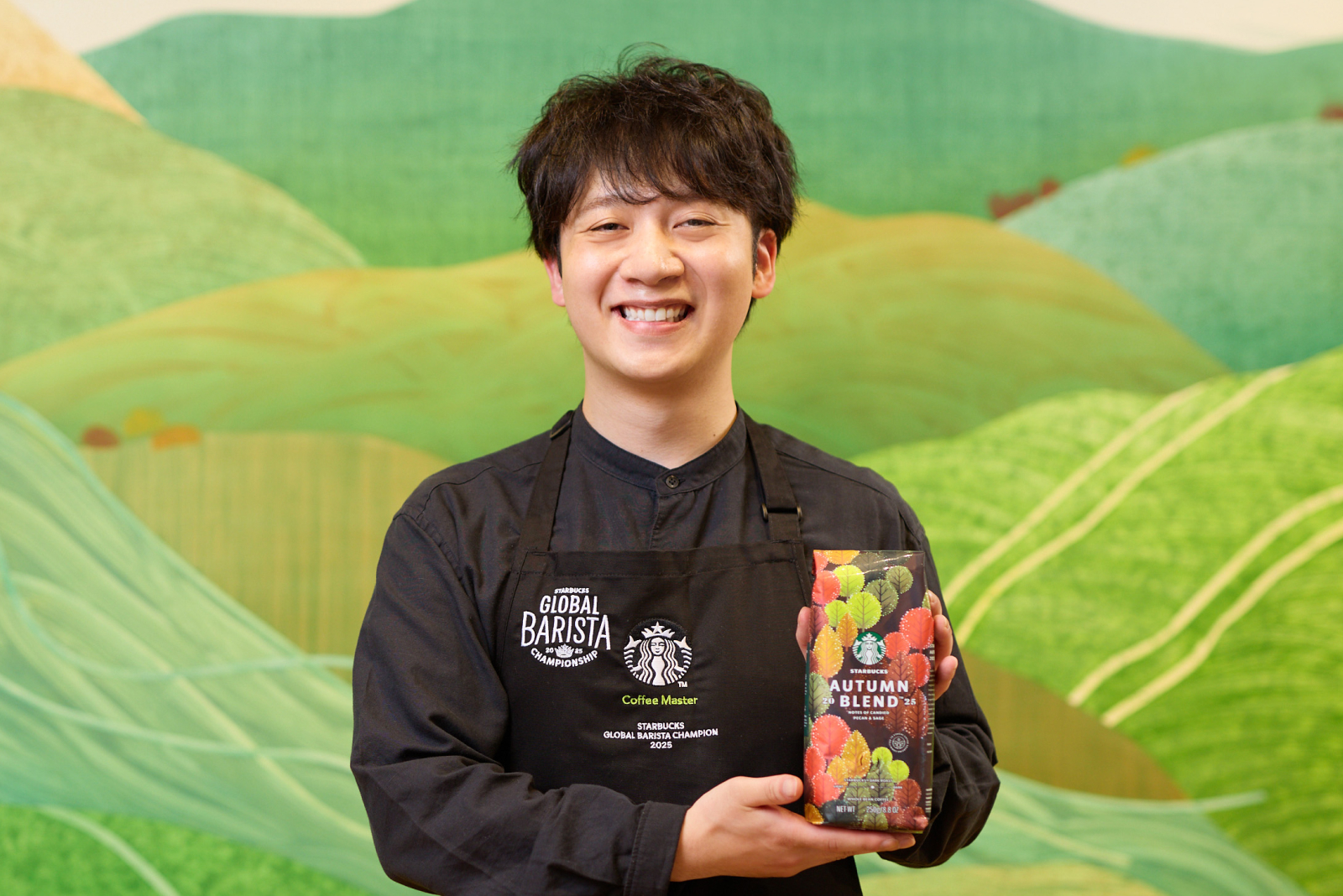 コーヒーアンバサダーの下出さんがスターバックス® オータム ブレンドのパッケージを手に抱えている様子