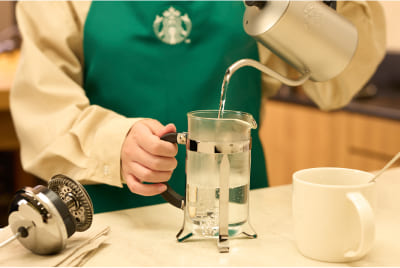 STEP1 コーヒープレスとマグカップにお湯を注いでいる様子